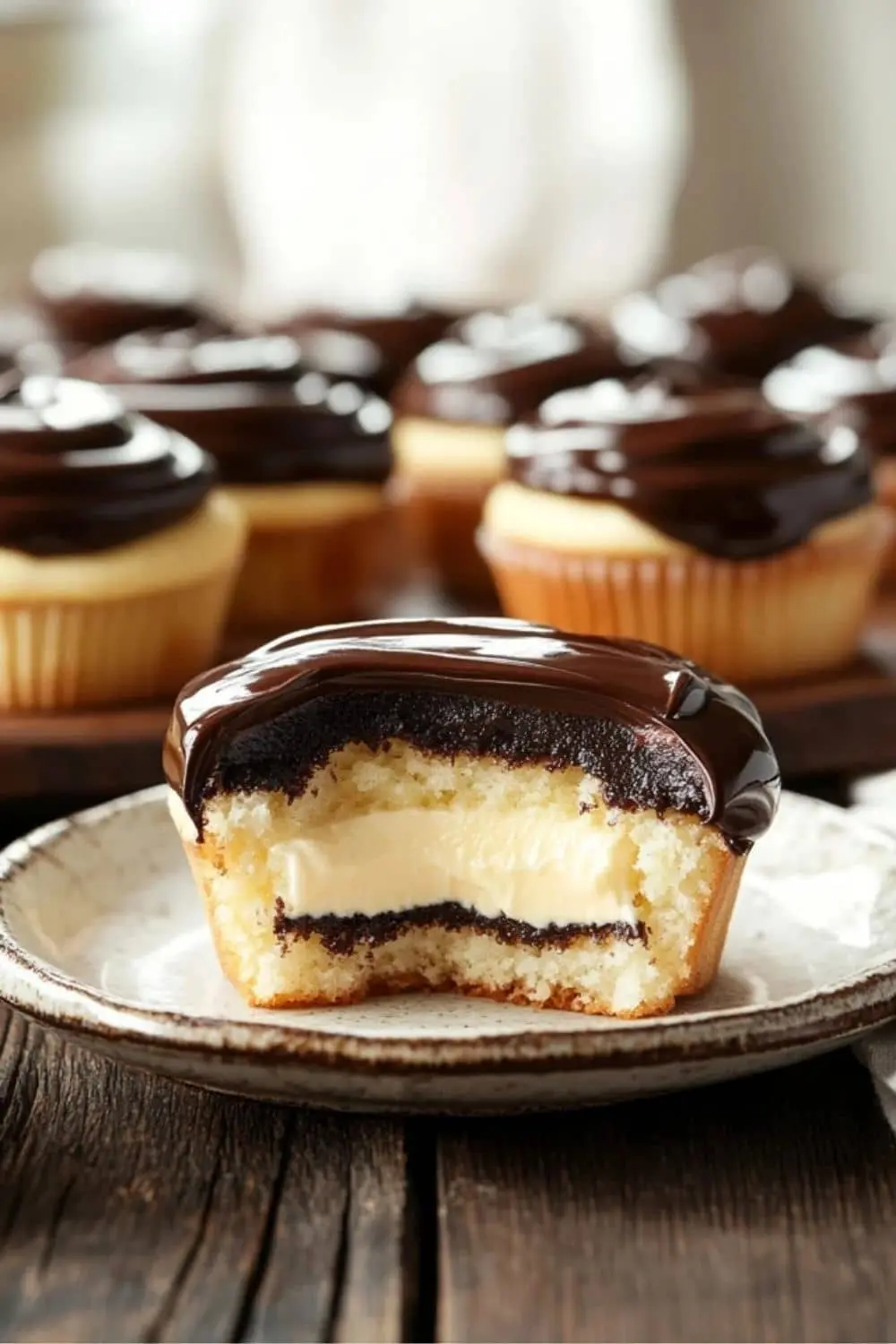 Freshly baked Boston Cream Pie Cupcakes with chocolate ganache.