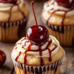 A plate of Cherry Bakewell Cupcakes with almond icing and glacé cherries
