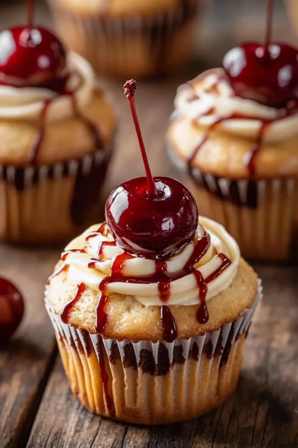A plate of Cherry Bakewell Cupcakes with almond icing and glacé cherries